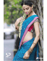 a woman in a blue and pink saree is leaning against a tree with the letters sp on the bottom