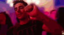 a blurry picture of a man in a club pointing at the camera