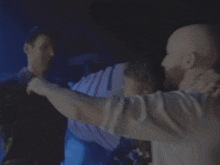 a man in a white shirt holds another man 's arm
