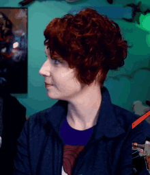a woman with red curly hair is wearing a blue jacket