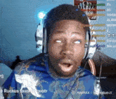 a man wearing headphones and a blue shirt says ruckus