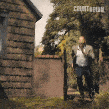 a man running in front of a building with the word countdown on the bottom