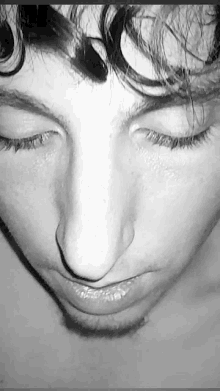 a black and white photo of a young man with his eyes closed