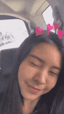 a woman is sitting in a car with hearts in her hair
