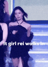a woman in a black dress with the words " it girl rei walks in " on the bottom