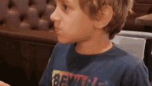 a young boy wearing a t-shirt that says beware on it