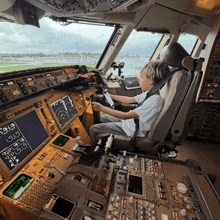 a young boy is sitting in the cockpit of an airplane with a display that says ' g ' on it