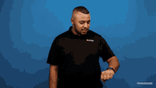 a man stands in front of a blue wall with the words where are yo written on it