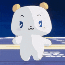 a white teddy bear with yellow ears and a blue eye