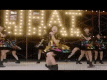 a group of women are dancing in front of a sign that says ' hit '