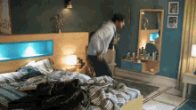 a man in a white shirt is jumping on a bed