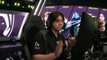 a man wearing headphones is sitting in front of a monitor with the name miniboo on it