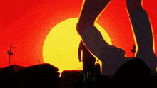 a silhouette of a person standing in front of a sunset