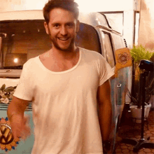 a man in a white shirt is standing in front of a blue van