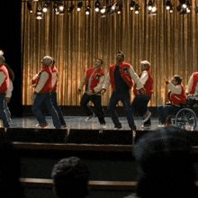 a group of people wearing varsity jackets with the letter m on them are performing on a stage