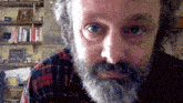 a man with a beard is wearing a plaid shirt and has the hashtag @itsscottiesstark above his face