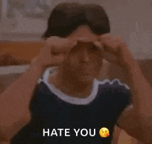 a young man is giving the middle finger and the words `` hate you '' are above him .