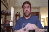 a man with a beard is sitting in a living room with a lamp and a clock .