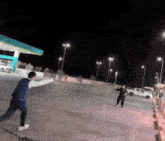 a man throws a frisbee at a woman in a parking lot at night