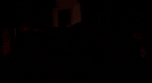 a man sits on a couch in a dark room with a picture on the wall