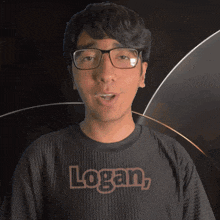 a man wearing glasses and a black shirt with the name logan on it