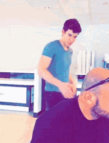 a man in a blue shirt is standing next to another man
