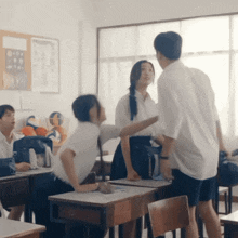 a group of students are having a fight in a classroom with a bulletin board in the background