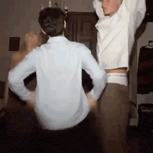 a couple of men are dancing together in a room .