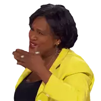 a woman in a yellow jacket is laughing with her hands outstretched