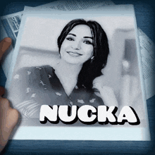 a person is holding a picture of a woman with the name nucka on it