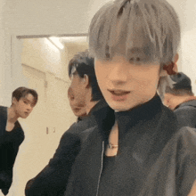 a group of young men are standing in a room .