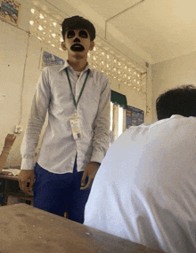 a man in a white shirt has a lanyard around his neck with a name tag that says ' a. ' on it