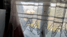 a white lace curtain with a geometric pattern on it