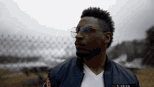 a man wearing sunglasses and a jacket with the name s. dean on it