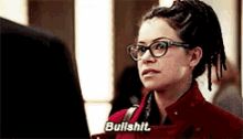 a woman wearing glasses and a red coat says bullshit .