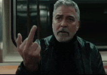 a man with gray hair and a beard giving the middle finger