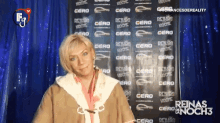 a woman is standing in front of a sign that says renas en noch3