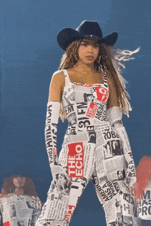 a woman wearing a cowboy hat and a newspaper jumpsuit
