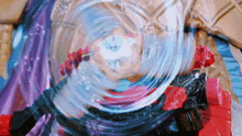a toy is spinning in a circle with a purple cloth in the background