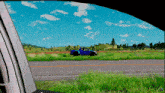 a blue truck is driving down a road in the countryside