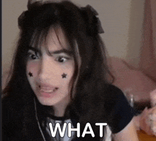 a girl with stars on her face has the word what written on her face