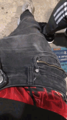 a person wearing a pair of black jeans with a zipper on the back