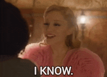 a woman in a pink dress is smiling and saying " i know "