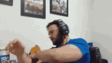 a man wearing headphones and a blue shirt is sitting in a chair