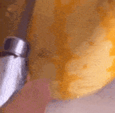a close up of a person holding a faucet over a yellow object