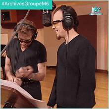two men wearing headphones in front of a microphone with #archivesgroupem6 written on the bottom