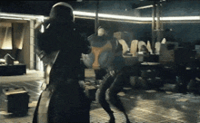 a man in a black suit is fighting another man in a black suit