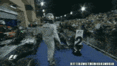 a man in a petronas uniform is walking towards a race car