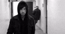 a black and white photo of a man in a hooded jacket