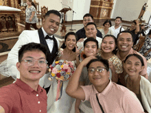 a group of people posing for a picture with a bride and groom in a church